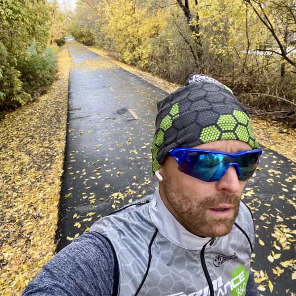 Cameron Hoffman running on a paved trail in fall conditions, wearing an Endurance360 jersey